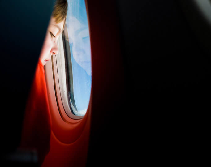 boy looking out of plane window