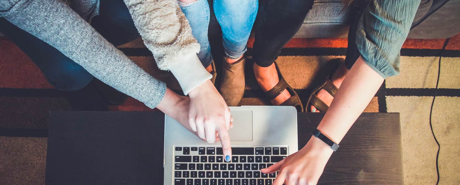 team of two people working on laptop together 